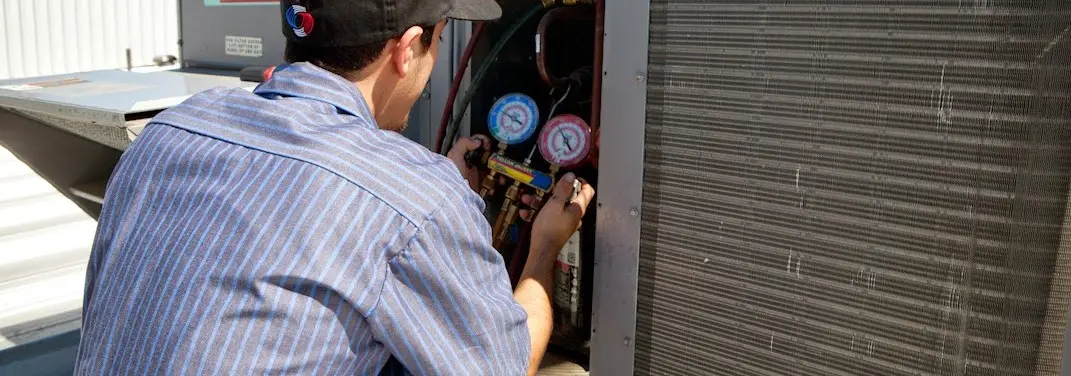 HVAC technician servicing a condenser unit in Mount Holly